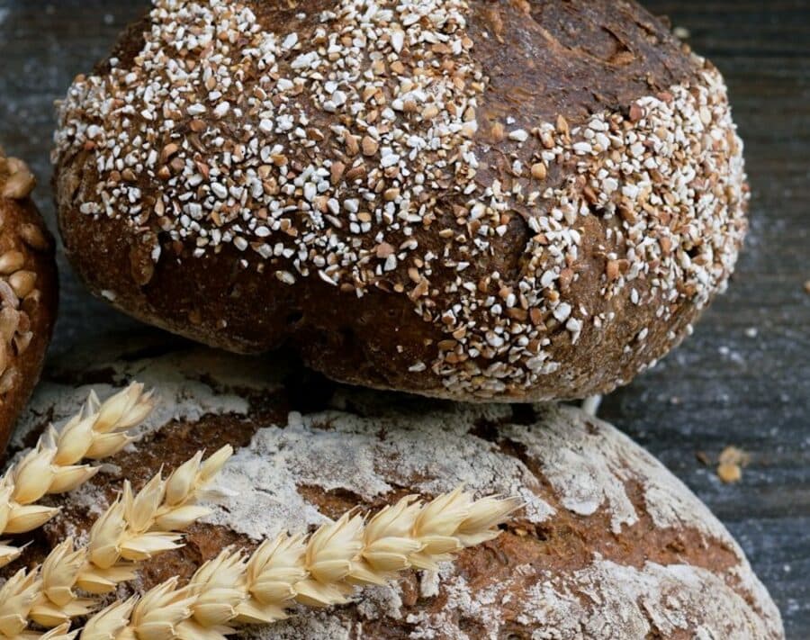 A dark rye loaf topped with cracked grains